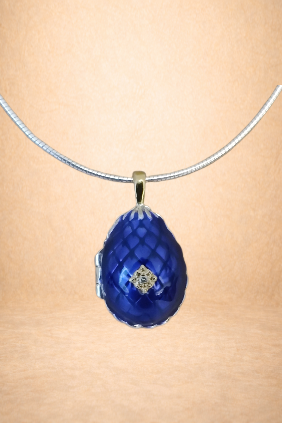 A necklace with a large blue pendant featuring a diamond-shaped design in the center, hanging from a silver chain.