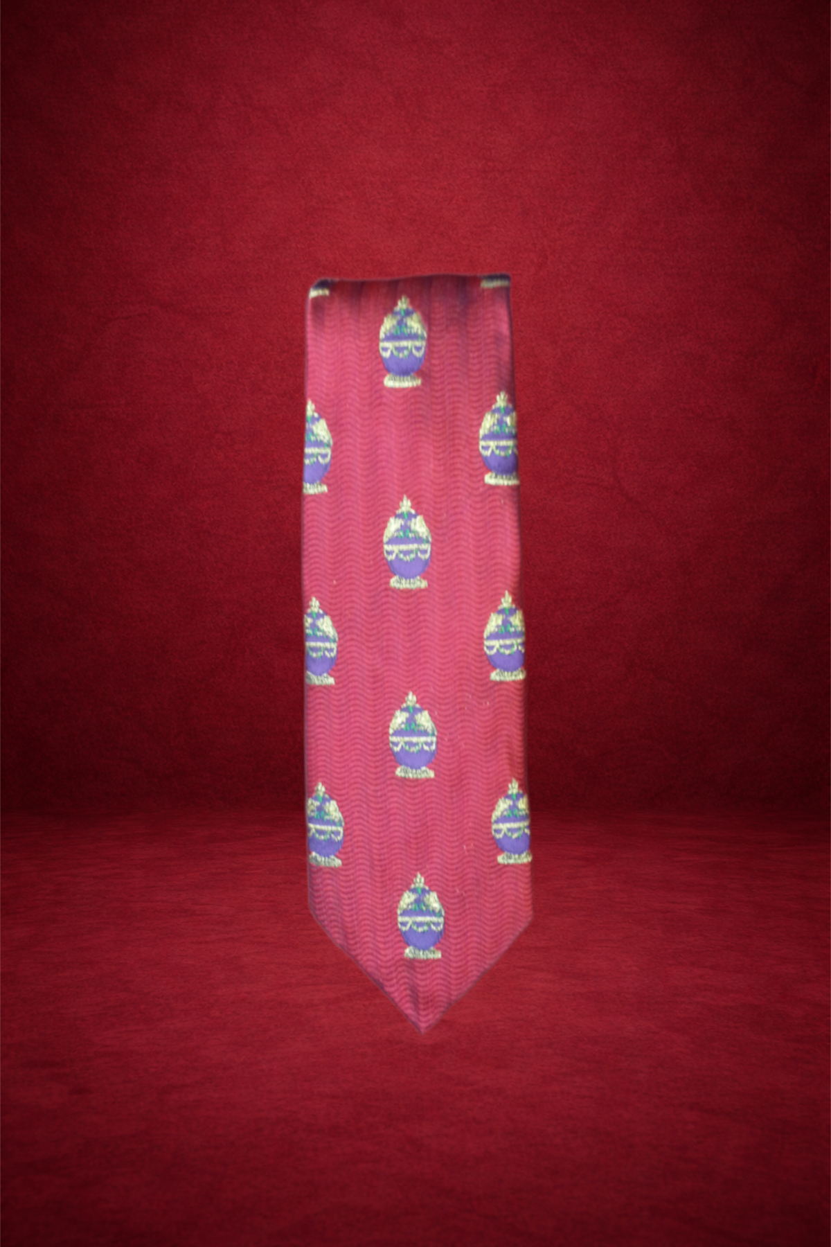 A close-up of a shirt with red and pink zigzag pattern and decorative egg motifs on a red background.