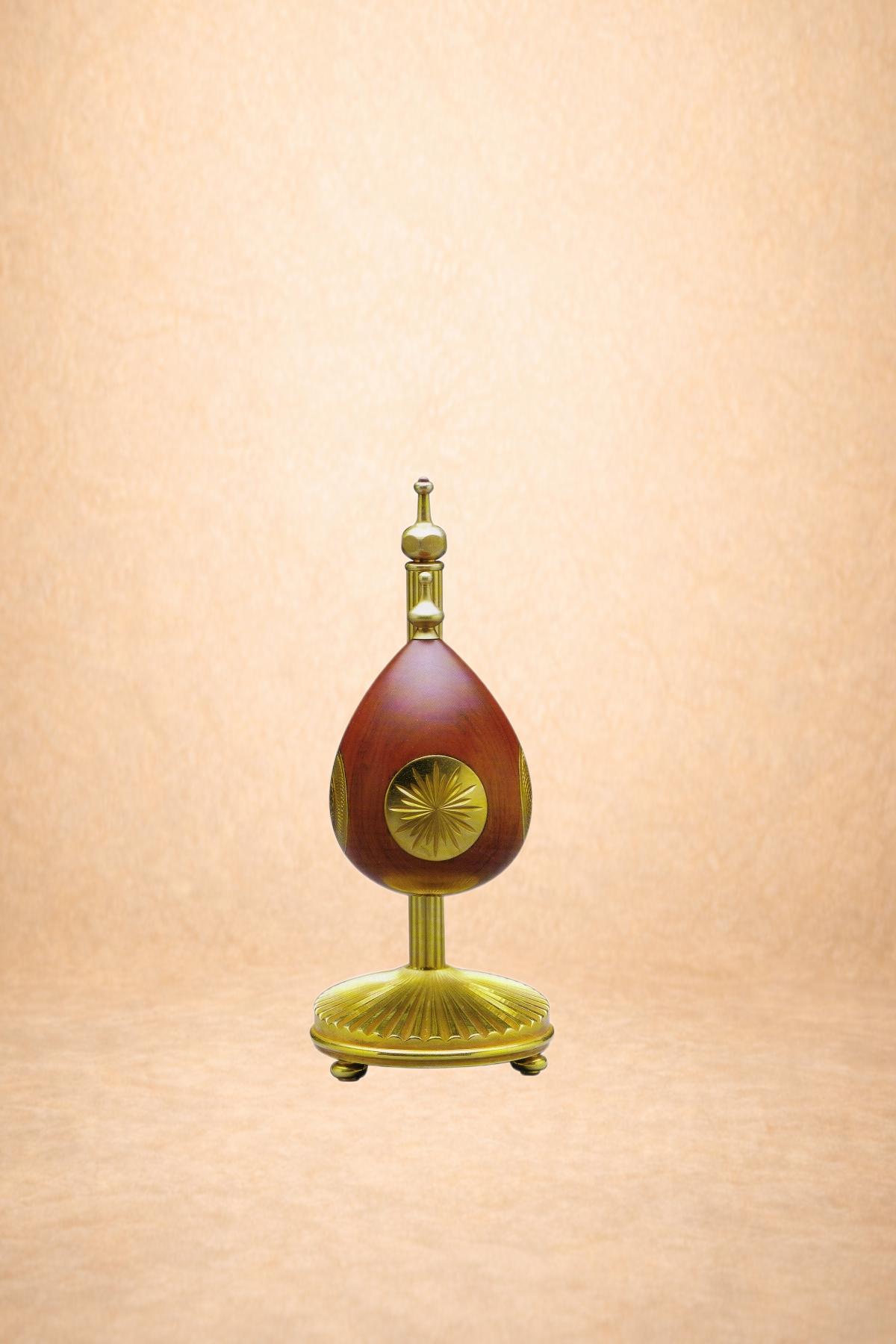 Decorative religious or ceremonial artifact with gold and reddish-brown elements, set against a light peach background.