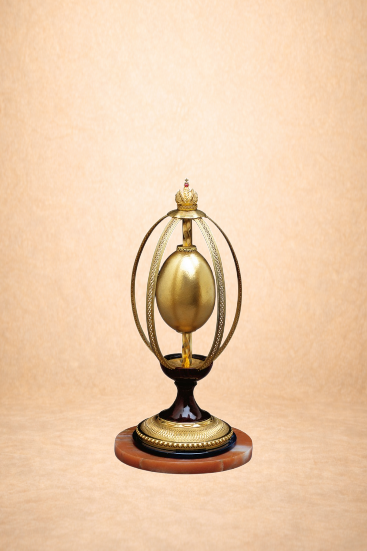 A religious artifact resembling a golden crown and egg, mounted on a stand with a round marble base, against a textured beige background.
