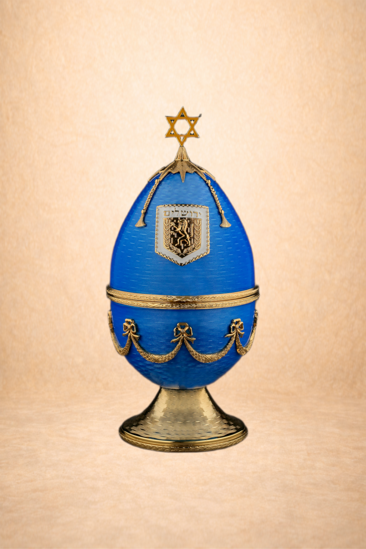 Decorative blue and gold egg-shaped ornament with a Star of David on top and a crest with a lion and Hebrew text in the center.