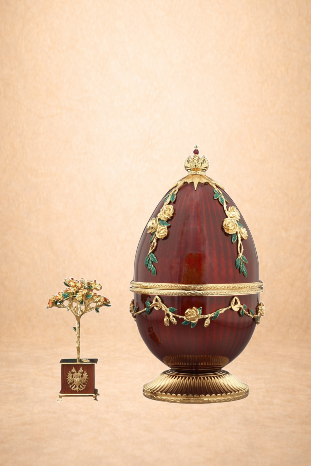 A decorative crown with gold and gemstone accents next to a large ornate egg with floral and crown details, set against a neutral background.
