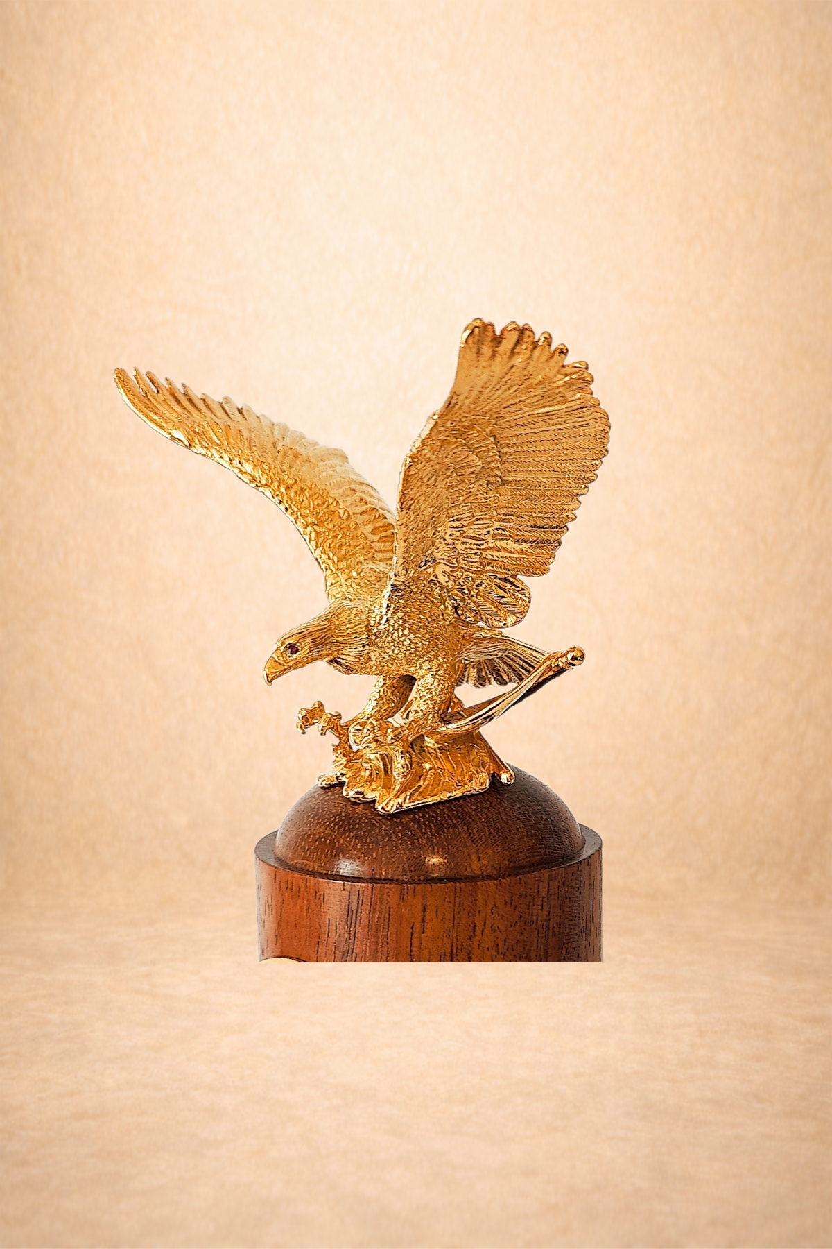 Gold-colored eagle sculpture perched on a wooden base.