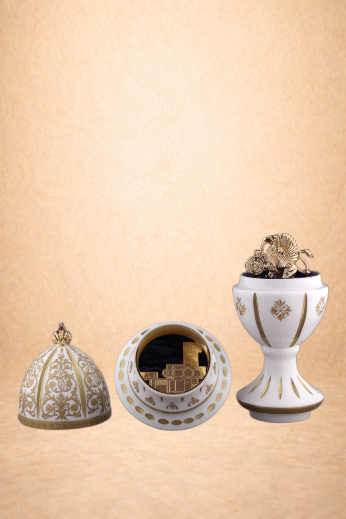 Decorative white and gold objects including a domed box, a circular mirror, and a trophy-like vessel with a lion, elephant, and tiger figurines on top.