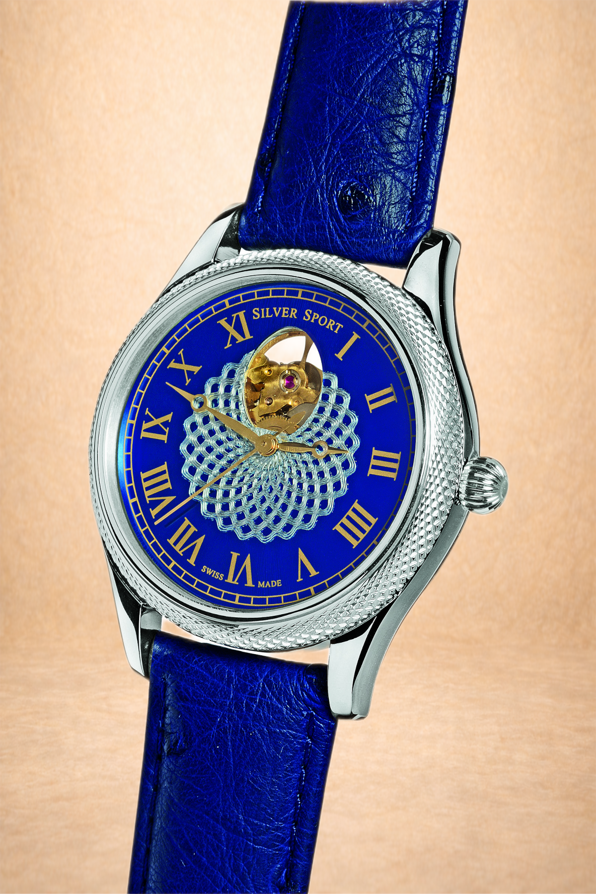 A close-up of a luxury wristwatch with a blue dial, gold Roman numerals, and an open heart design showing the watch's internal moving parts, mounted on a blue leather strap.