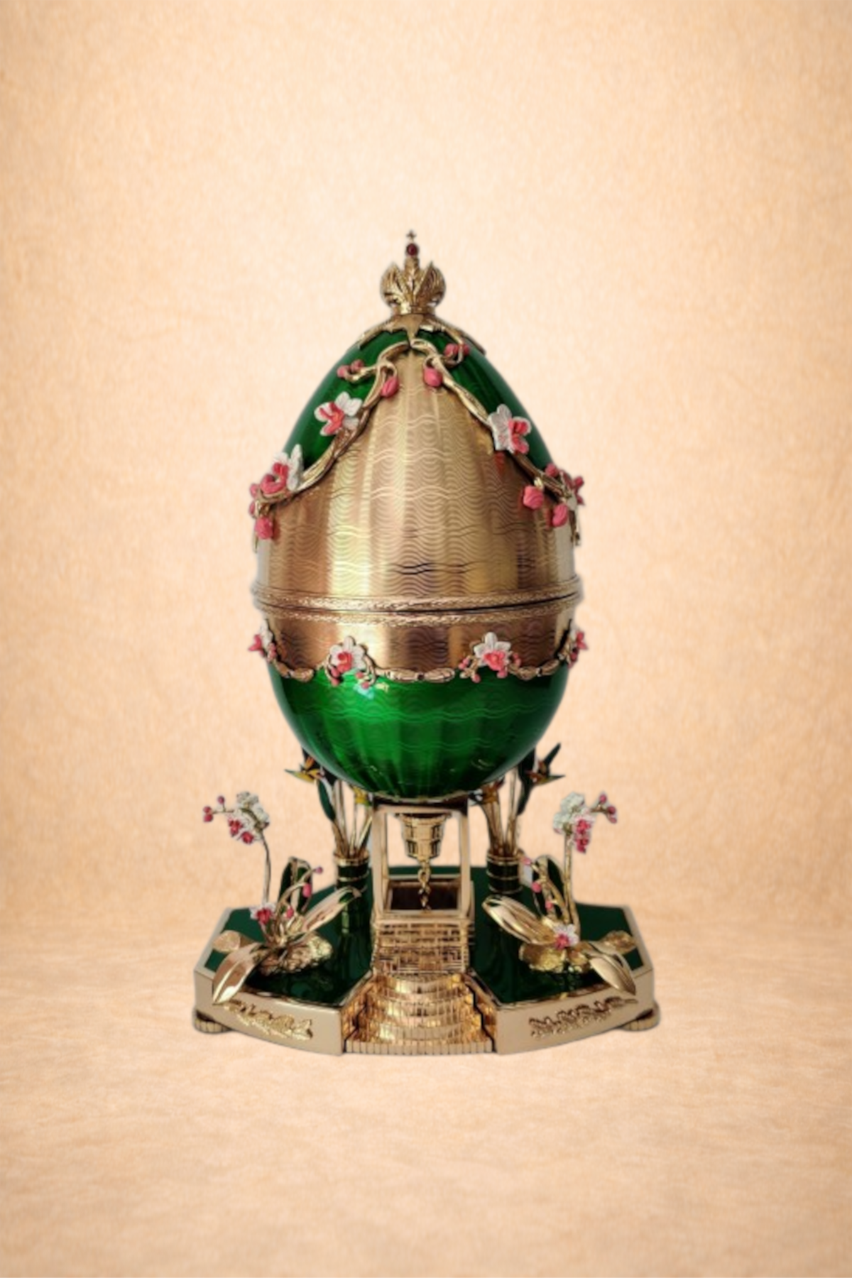 A decorative egg-shaped object with floral and crown embellishments, featuring green and gold colors, mounted on a stand with rabbit figures.