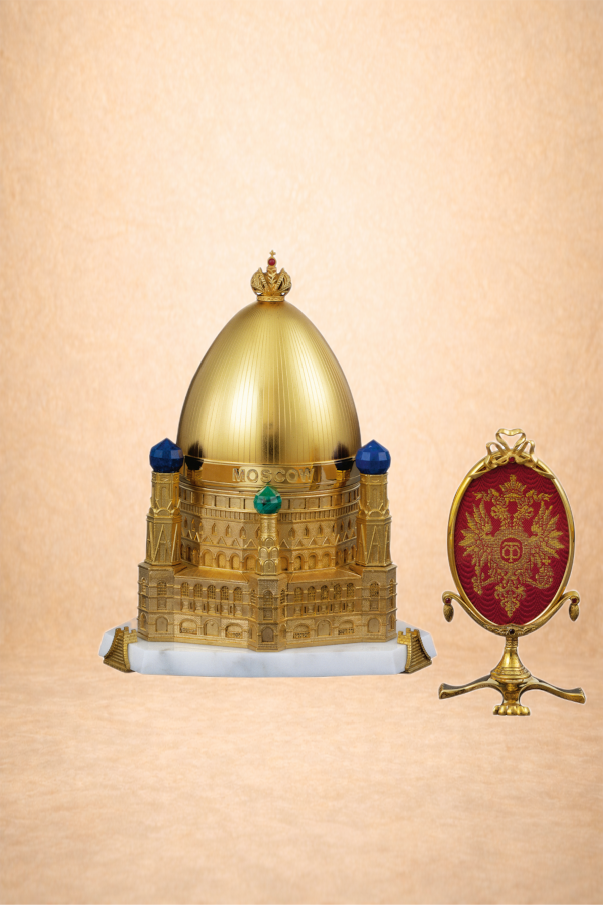 Decorative jewelry box shaped like a gold dome with green, blue, and red accents, and the word 'MOSCOW' on it, next to a red and gold emblem with double-headed eagle design.