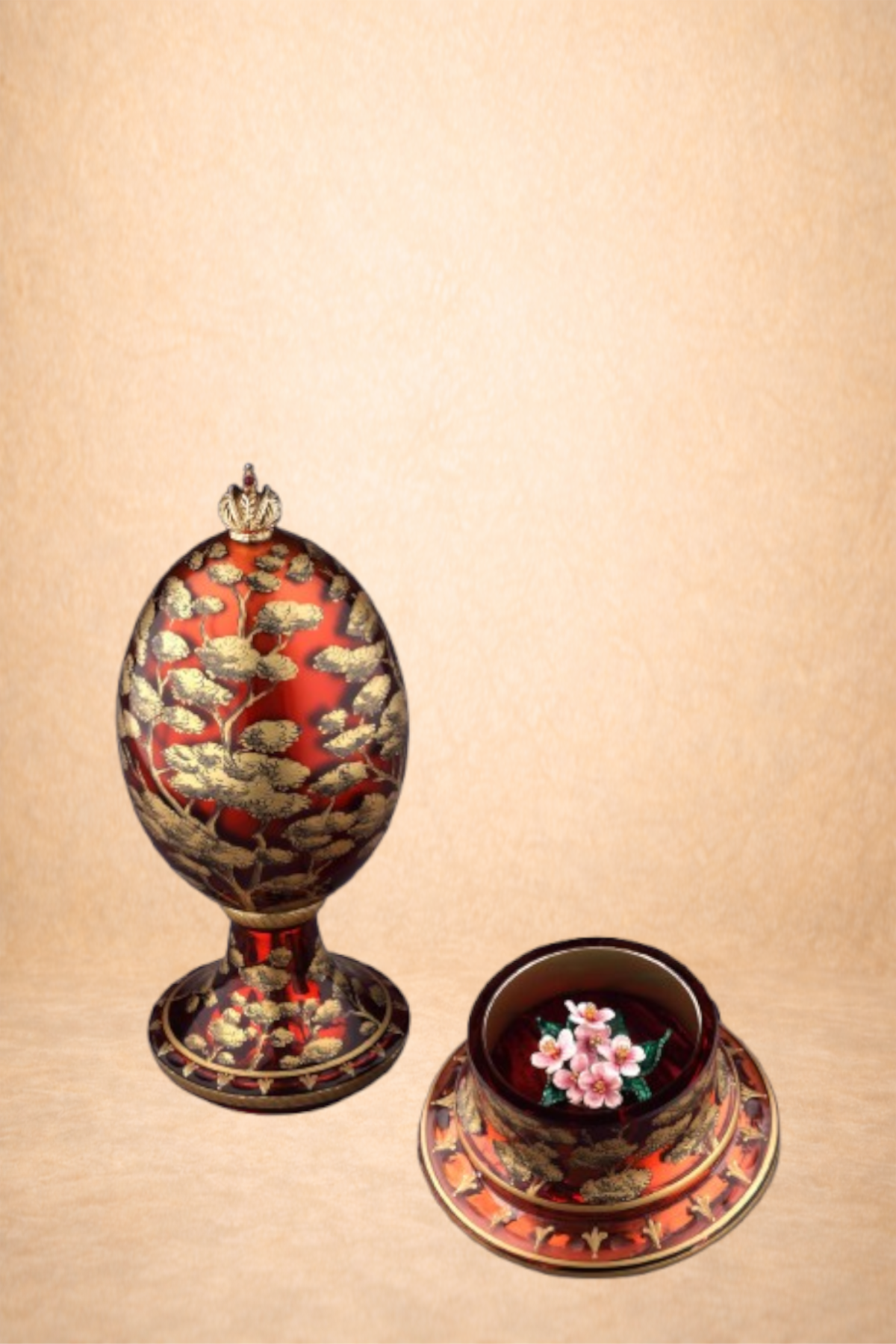 Decorative candlestick holder with intricate gold and black design on a red background, shaped like an egg with a small crown on top, and a matching tray with a floral design, next to a bowl with pink flowers inside.
