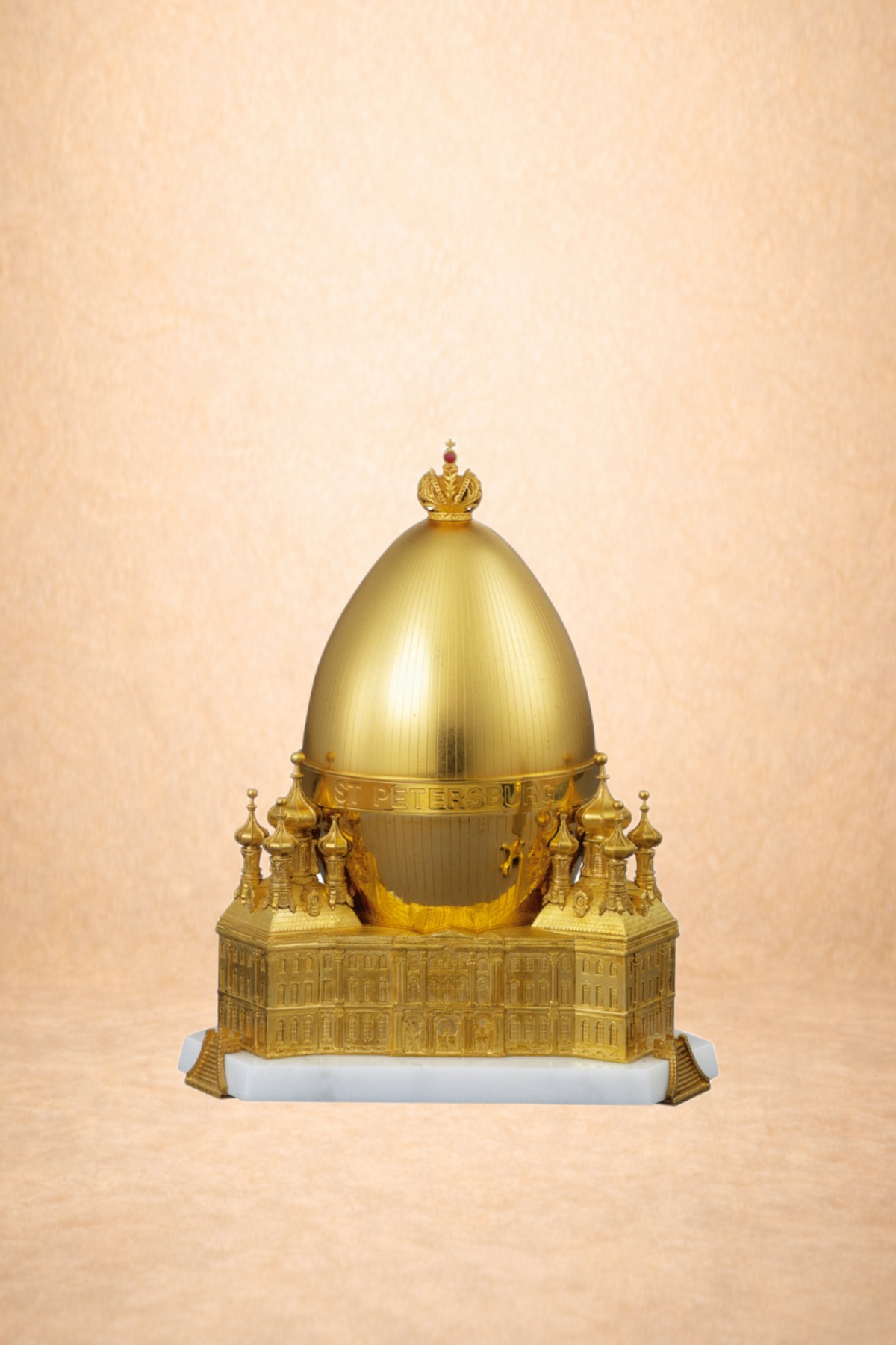 A detailed golden model of Saint Isaac's Cathedral in Saint Petersburg, Russia, featuring a large golden dome, intricate architectural details, and a base with text reading 'ST PETERSBURG'.