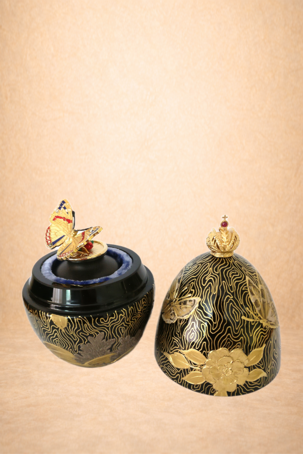 Decorative black and gold container with butterfly, crown, and floral motifs.