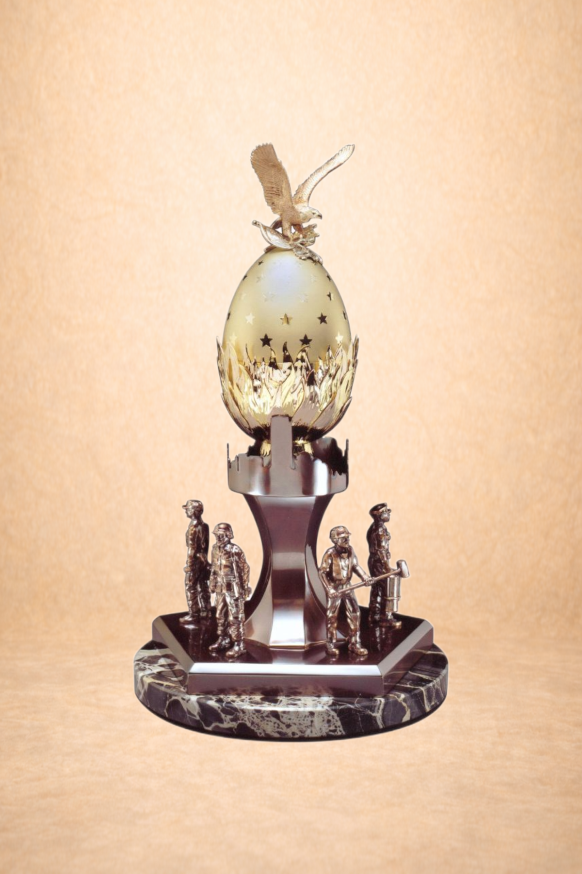 A decorative trophy featuring an eagle perched on an egg surrounded by miniature figures of construction workers on a marble base.