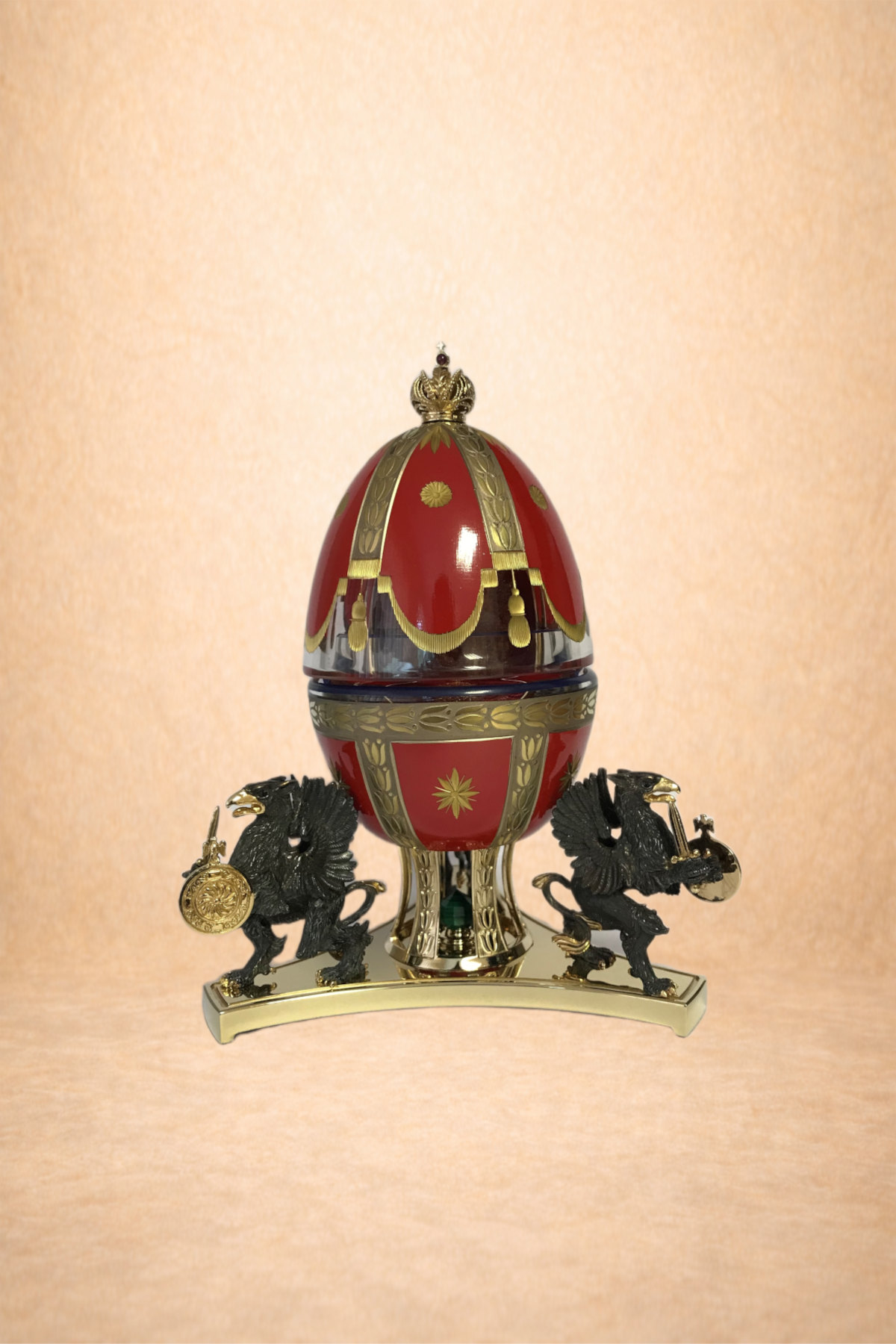A decorative object resembling an ornate egg held by two black lion figures with gold accents, set against a light beige background.