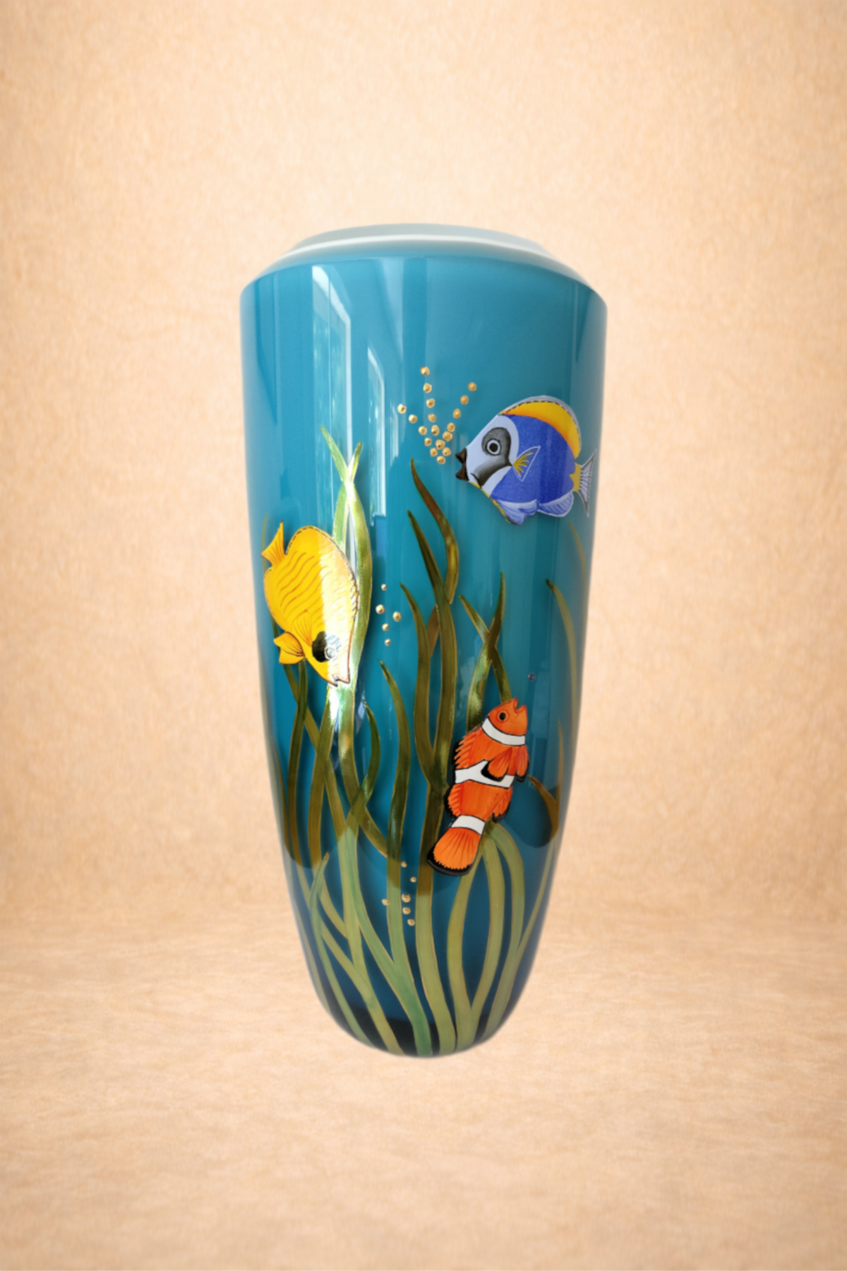 A decorative cylindrical vase with a blue background featuring colorful tropical fish and seaweed designs.