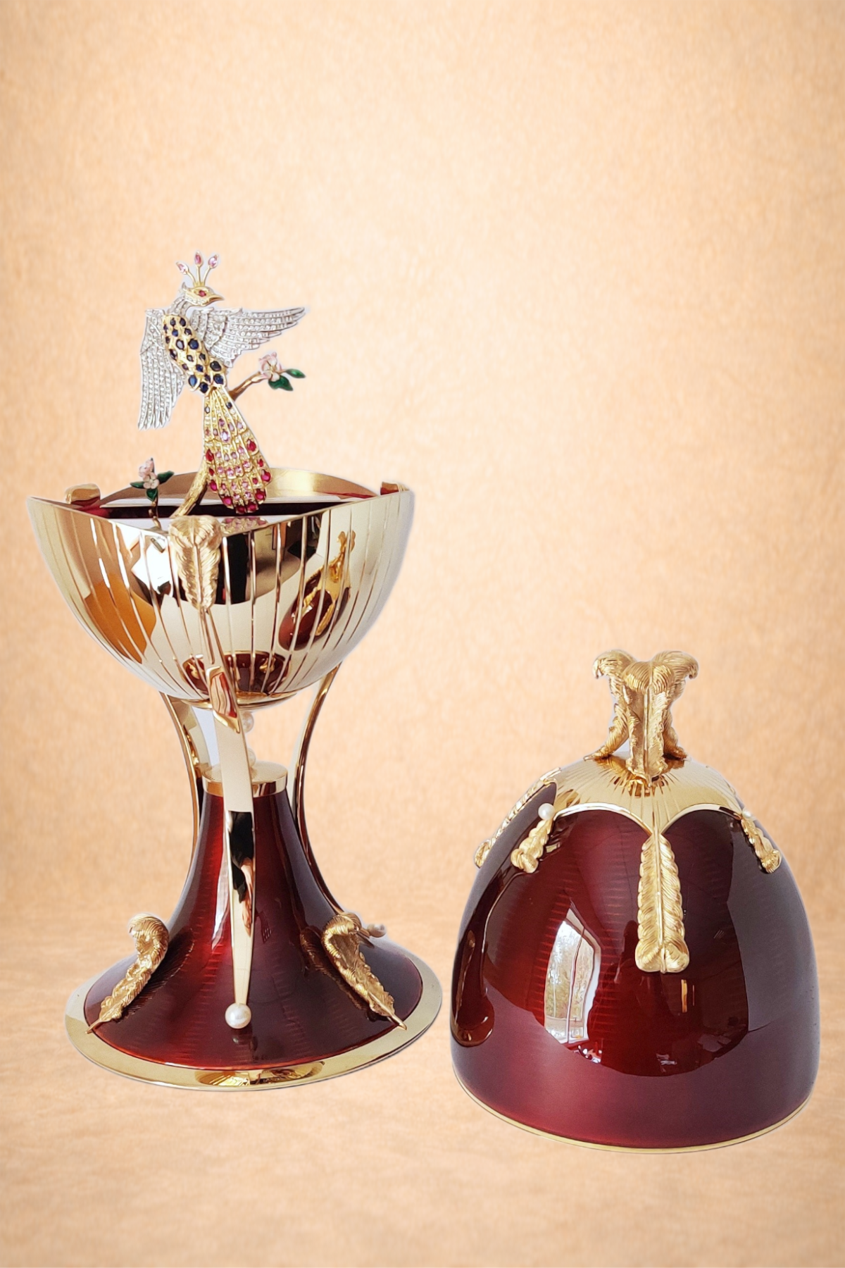 Decorative perfume bottles with gold accents and intricate designs, one with a peacock figurine on top and the other with a golden floral ornament, set against a beige background.