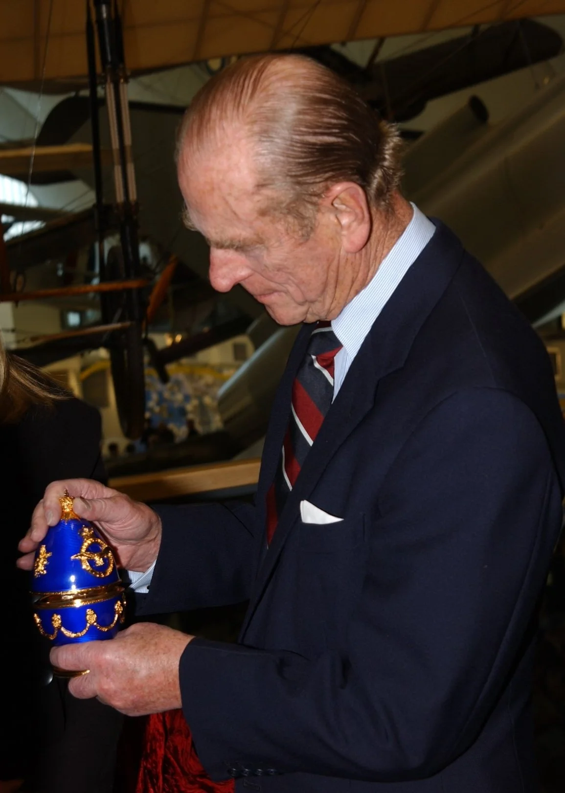 Prince Philip examining a handcrafted Fabergé-style egg creation representing the connection between the British Royal Family and Fabergé craftsmanship.