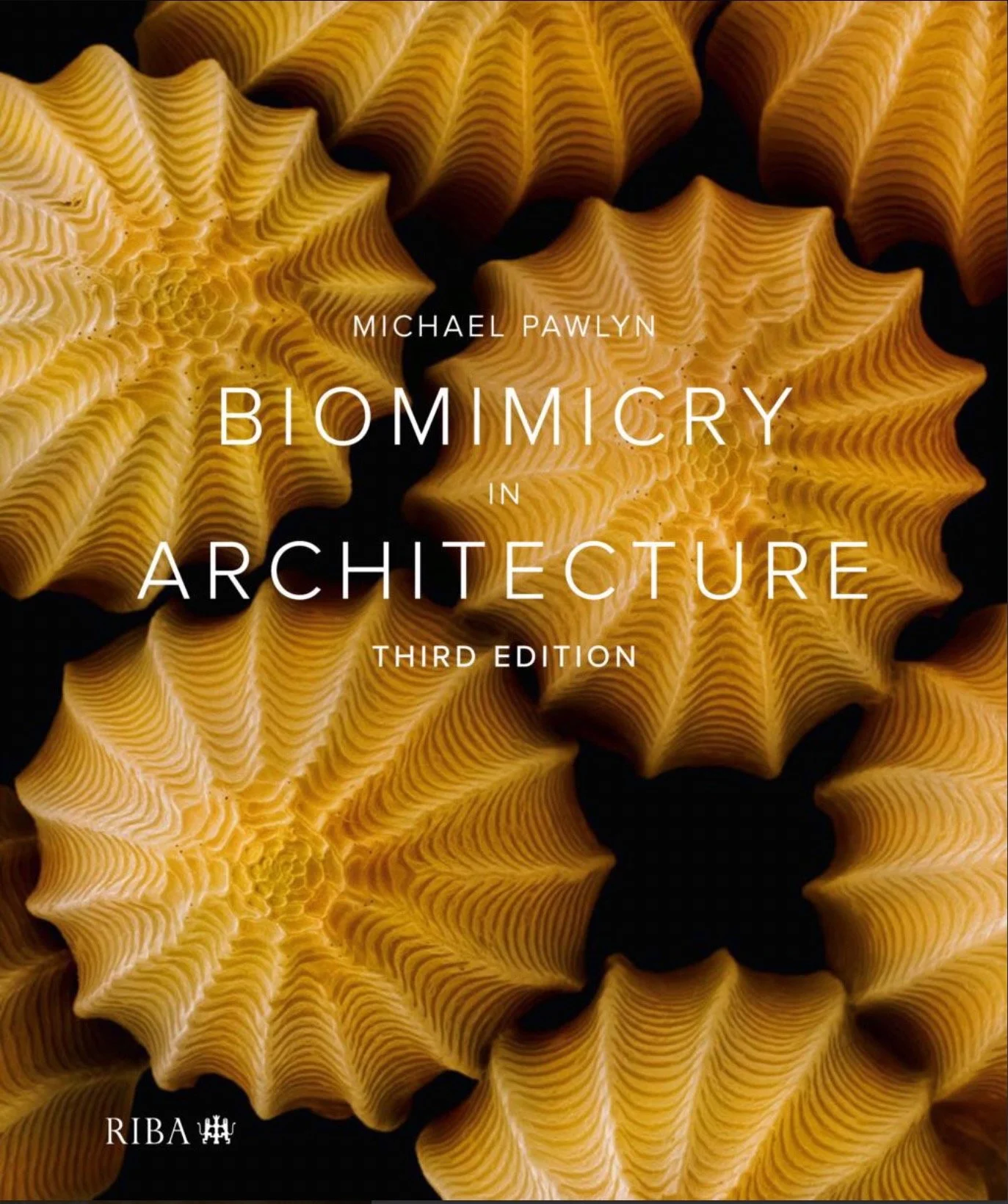 Cover of the book titled 'Biomimicry in Architecture' by Michael Pawlyn, with a background of yellow spiral shells.