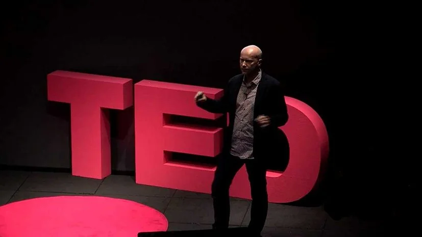 Michael Pawlyn standing on stage in front of large pink letters spelling 'TED' on a black background.