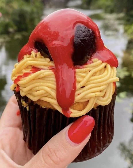 A spaghetti‑and‑meatballs–themed cupcake held outdoors, the same dessert from the Disney moment described in the post.