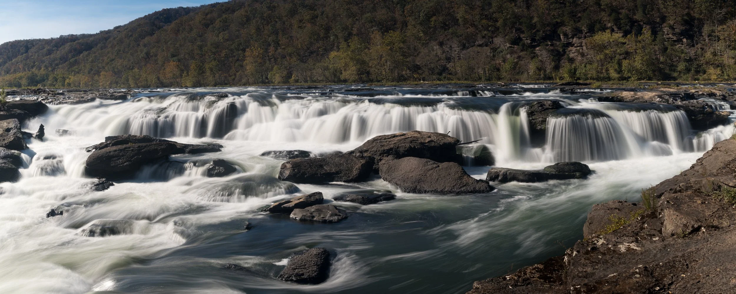 Falls on the New River in Virginia, with flat rocks in the foreground and fall foliage on the mountains — a metaphor for career seasons and the journey toward financial independence.
