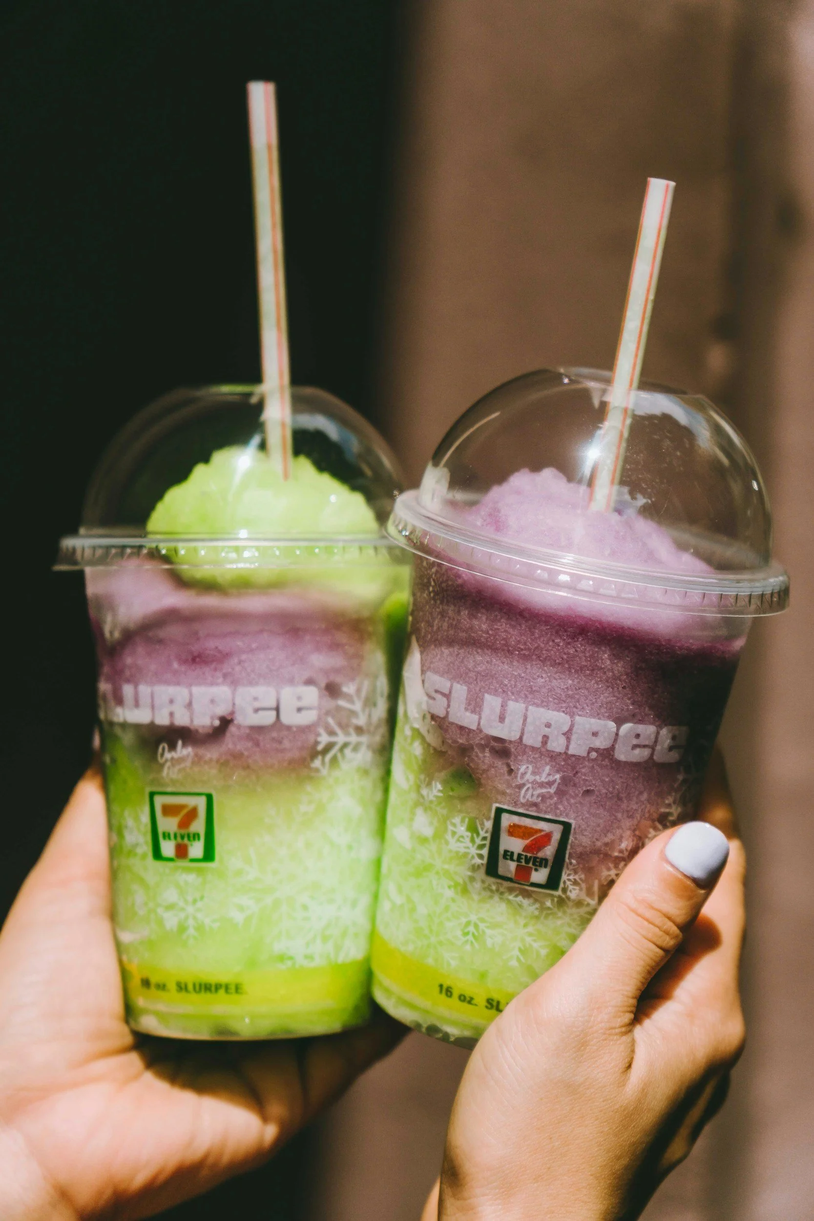 Two colorful 7-Eleven Slurpee cups held together representing a shared moment and lasting partnership.