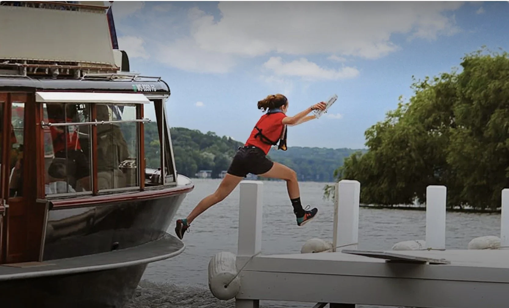 A mail jumper leaps mid-air from a dock onto a moving wooden tour boat on Geneva Lake Wisconsin — illustrating the perfect timing required for a well-timed career exit.