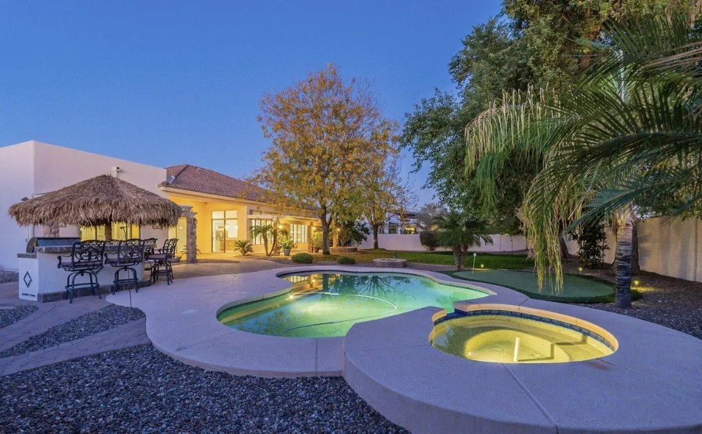 Glowing Arizona backyard pool at dusk with tiki bar — the McMansion lifestyle that looked like success but felt like an anchor.