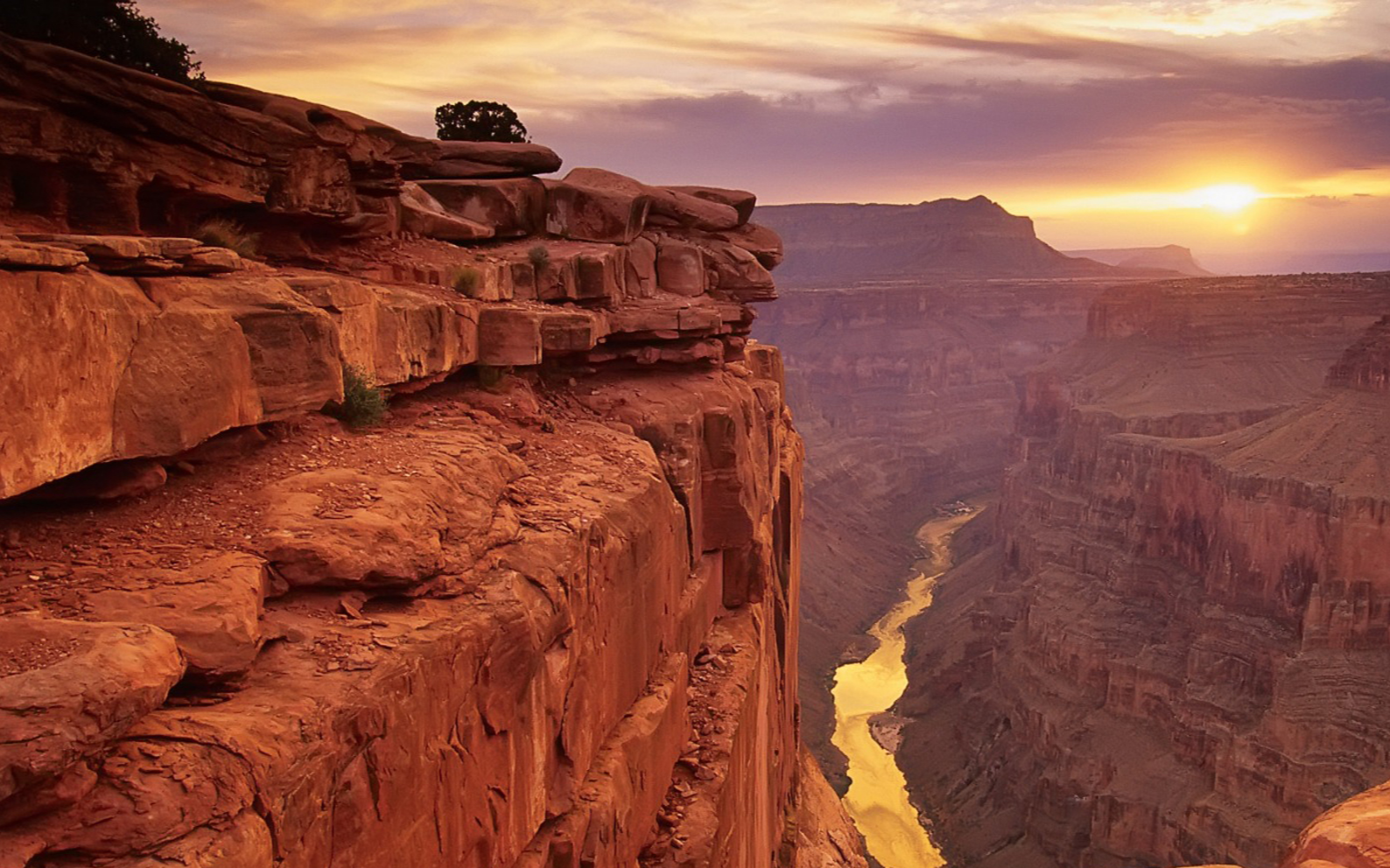 Grand Canyon at sunrise with golden light spreading across layered red canyon walls, evoking a sense of renewal and perspective.