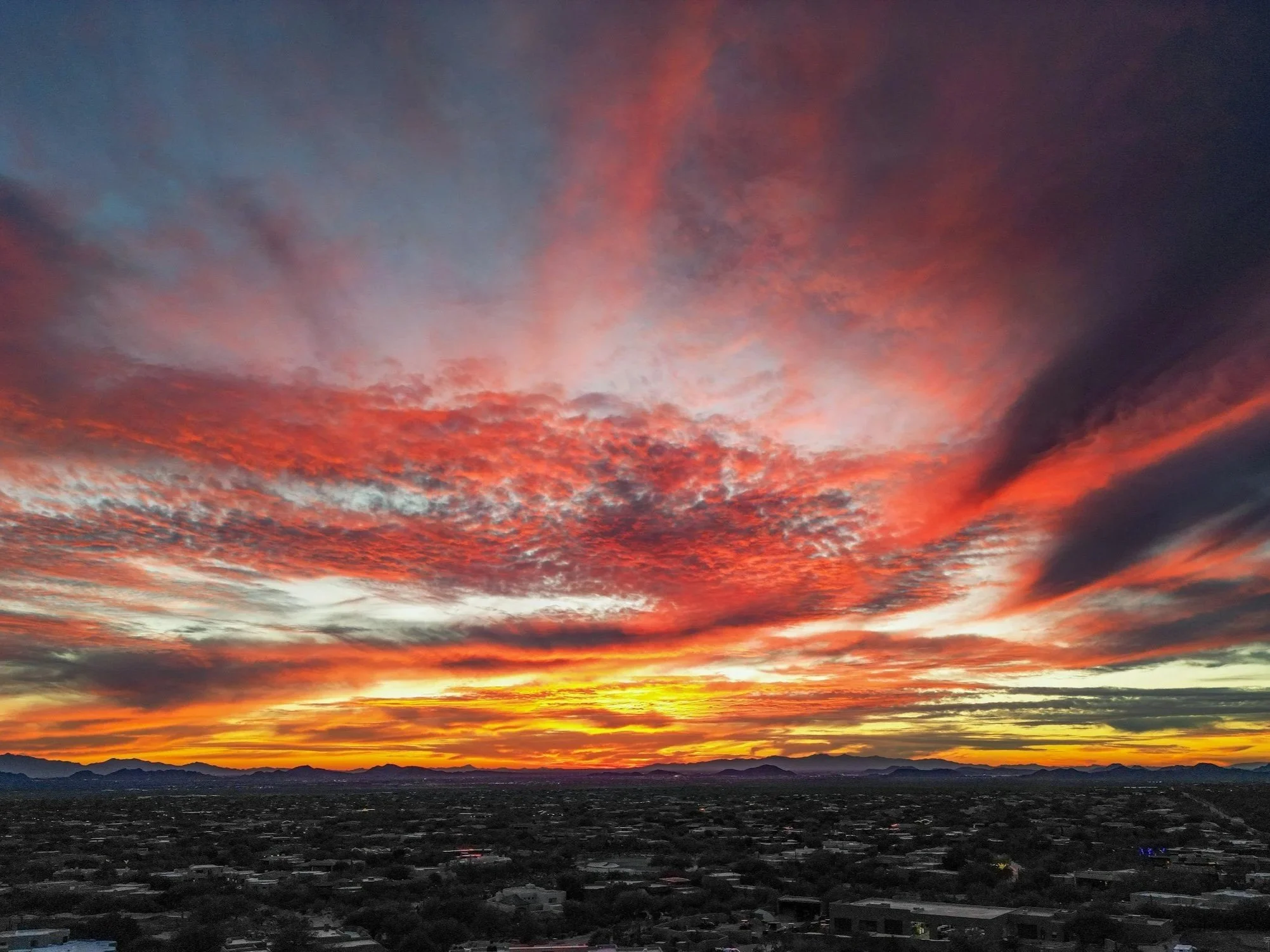 Arizona desert neighborhood at sunset with mountains in the background.