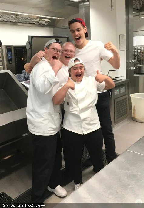 Vier lachende Mitarbeiter in der Küche