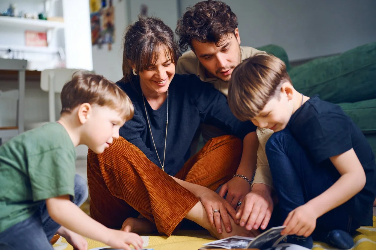 Family enjoying a moment on the floor, looking at photo albums together.