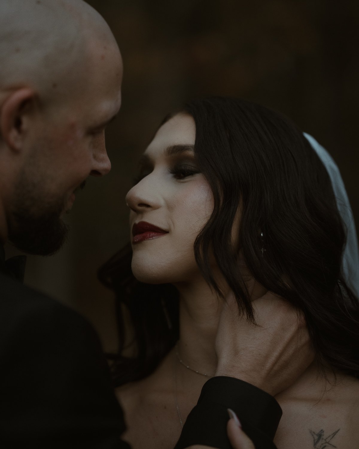 A close-up of a man and woman looking at each other affectionately indoors.