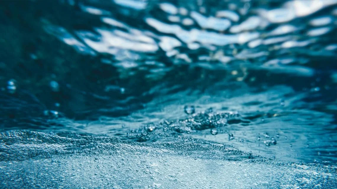 Close-up of water surface with bubbles and ripples