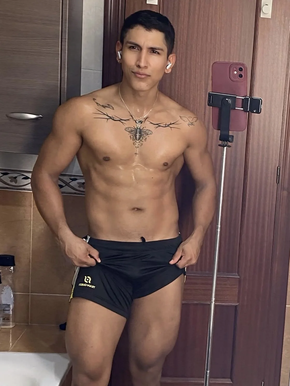 Jeferson stands shirtless, taking a selfie