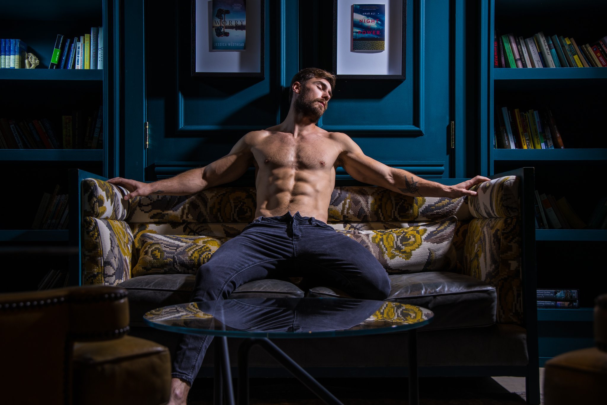Craig Marks poses shirtless on a sofa