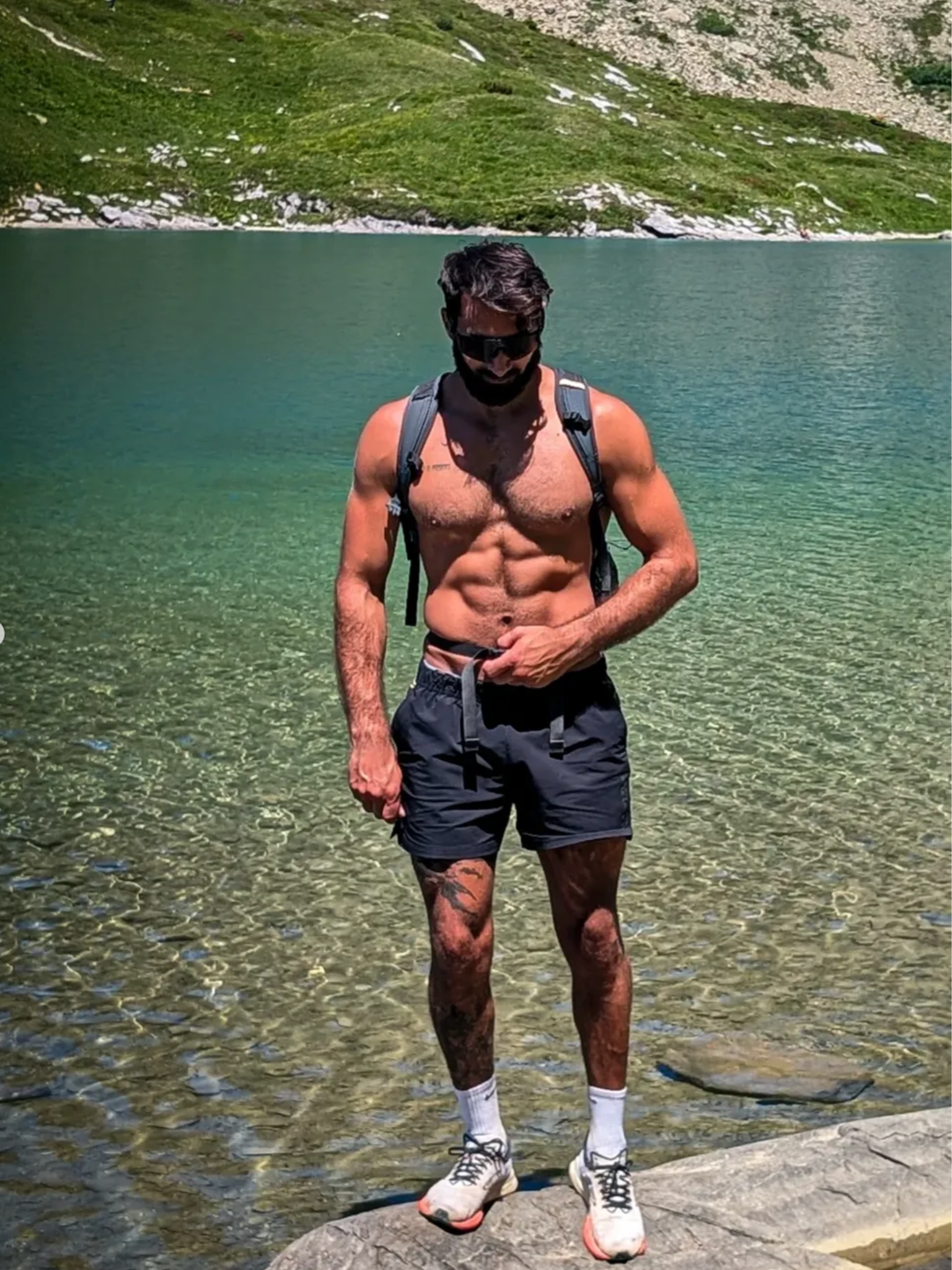 Stephano Lupo standing shirtless by a lake