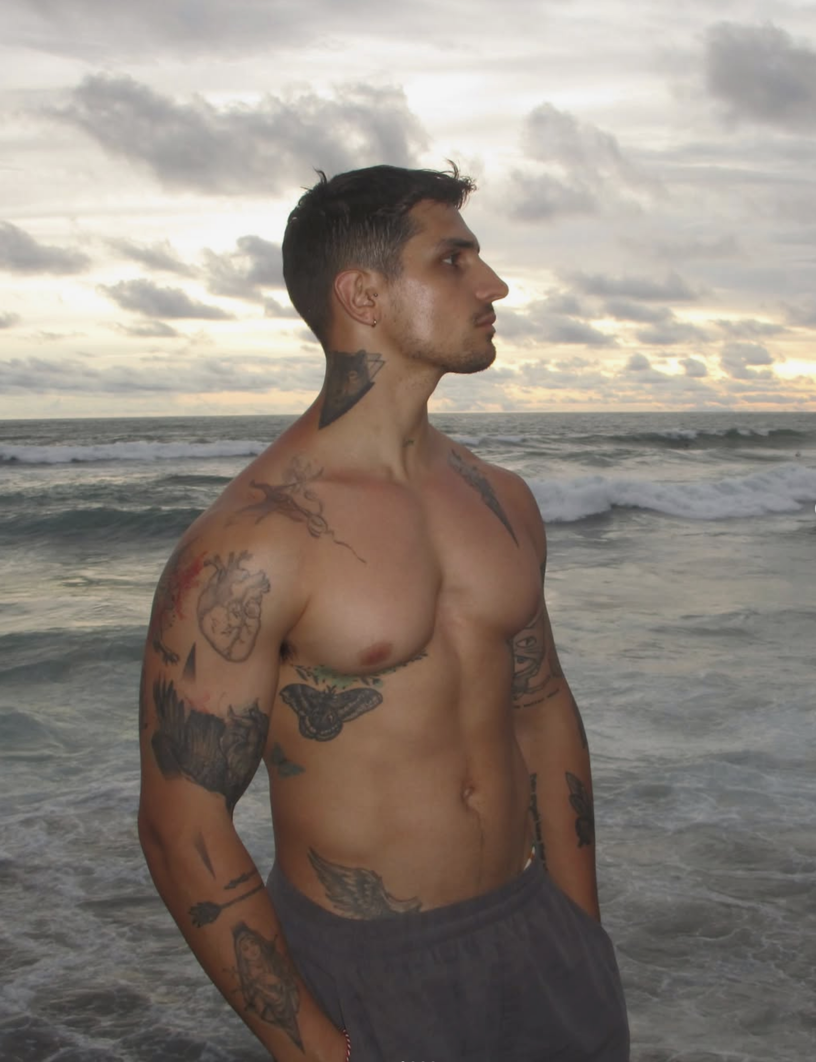 Manuel posing shirtless by the sea