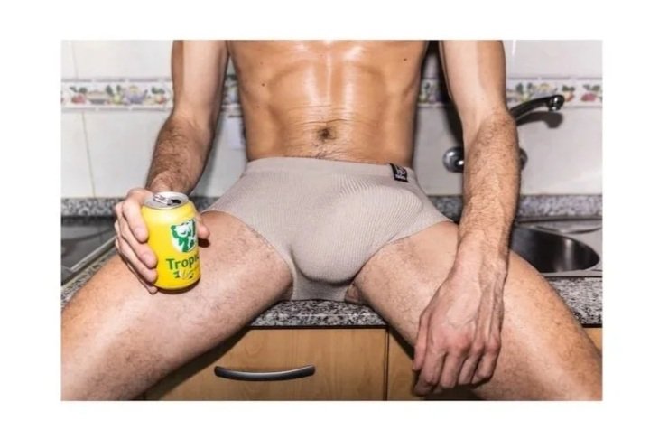 The abs and thighs of a fit man, holding a lemonade can. The penis is erected in the underpants. Photo by @papagnimeca