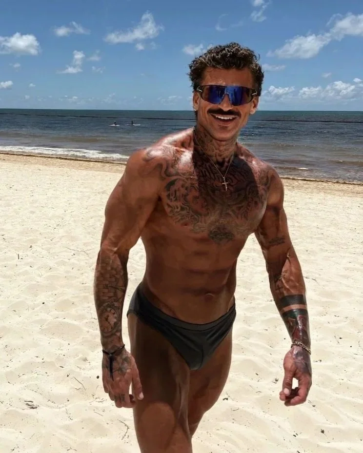 Ethan-James on the beach wearing Speedos