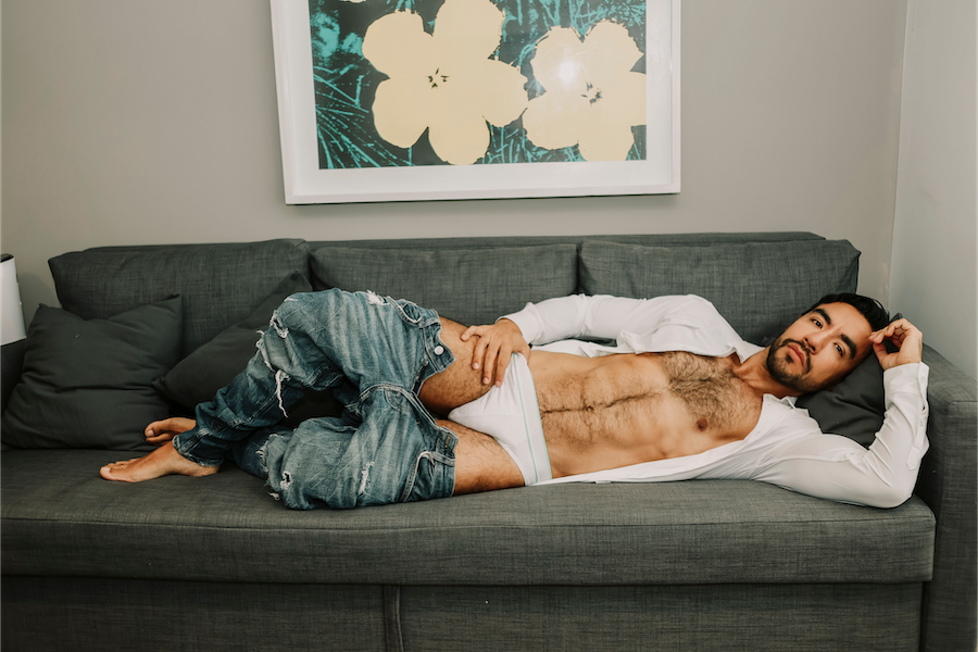 Alejandro laying on the sofa pants pulled down and shirt open