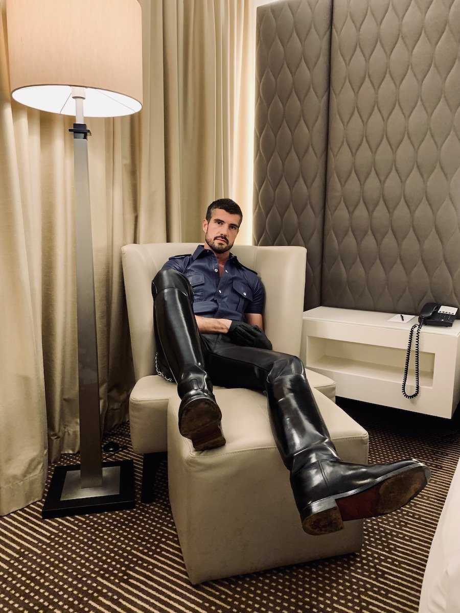 Thibaud sitting on a sofa wearing leather and black boots