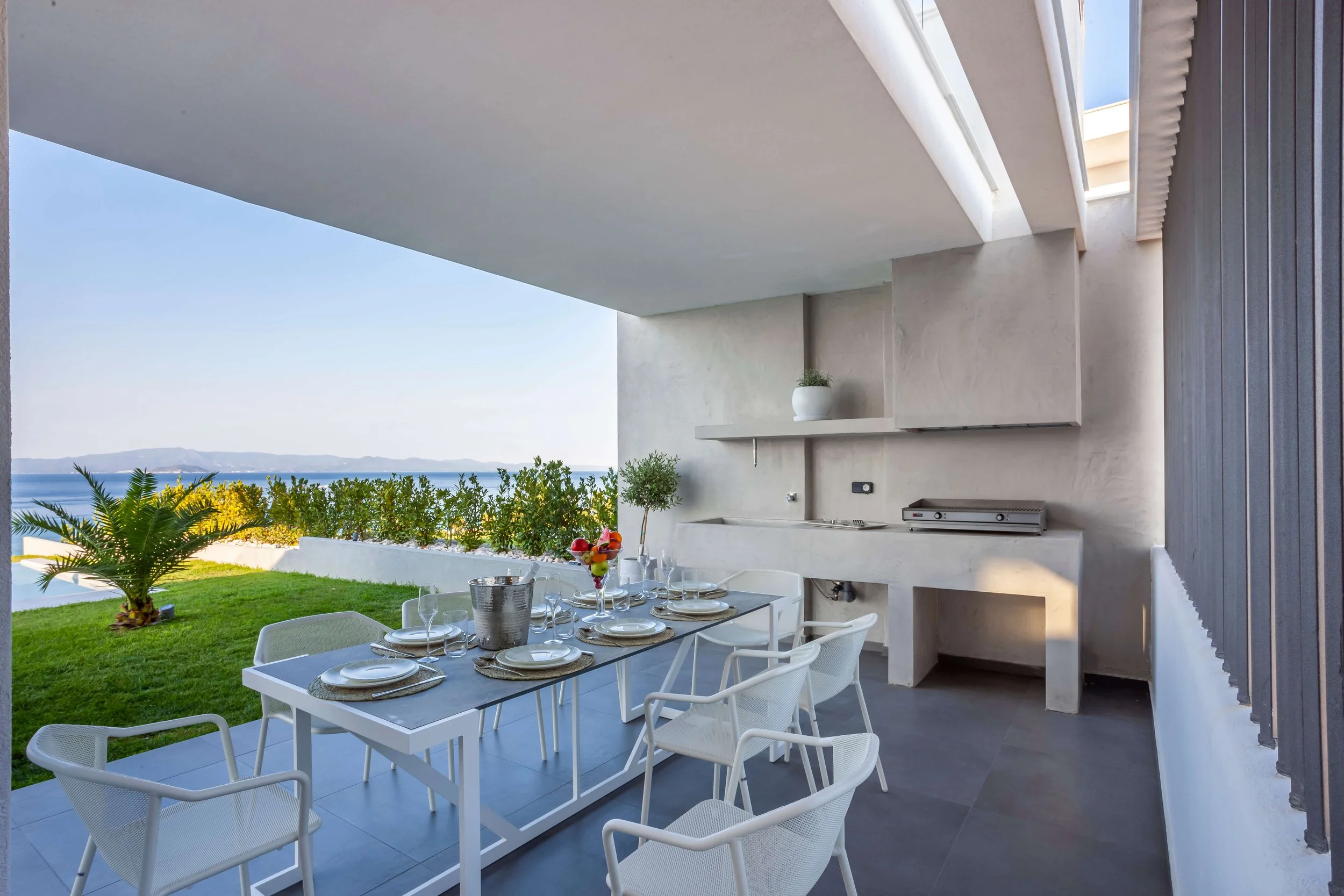 Antonio Villa outdoor dining area with bar counter and sea view seating Hanioti