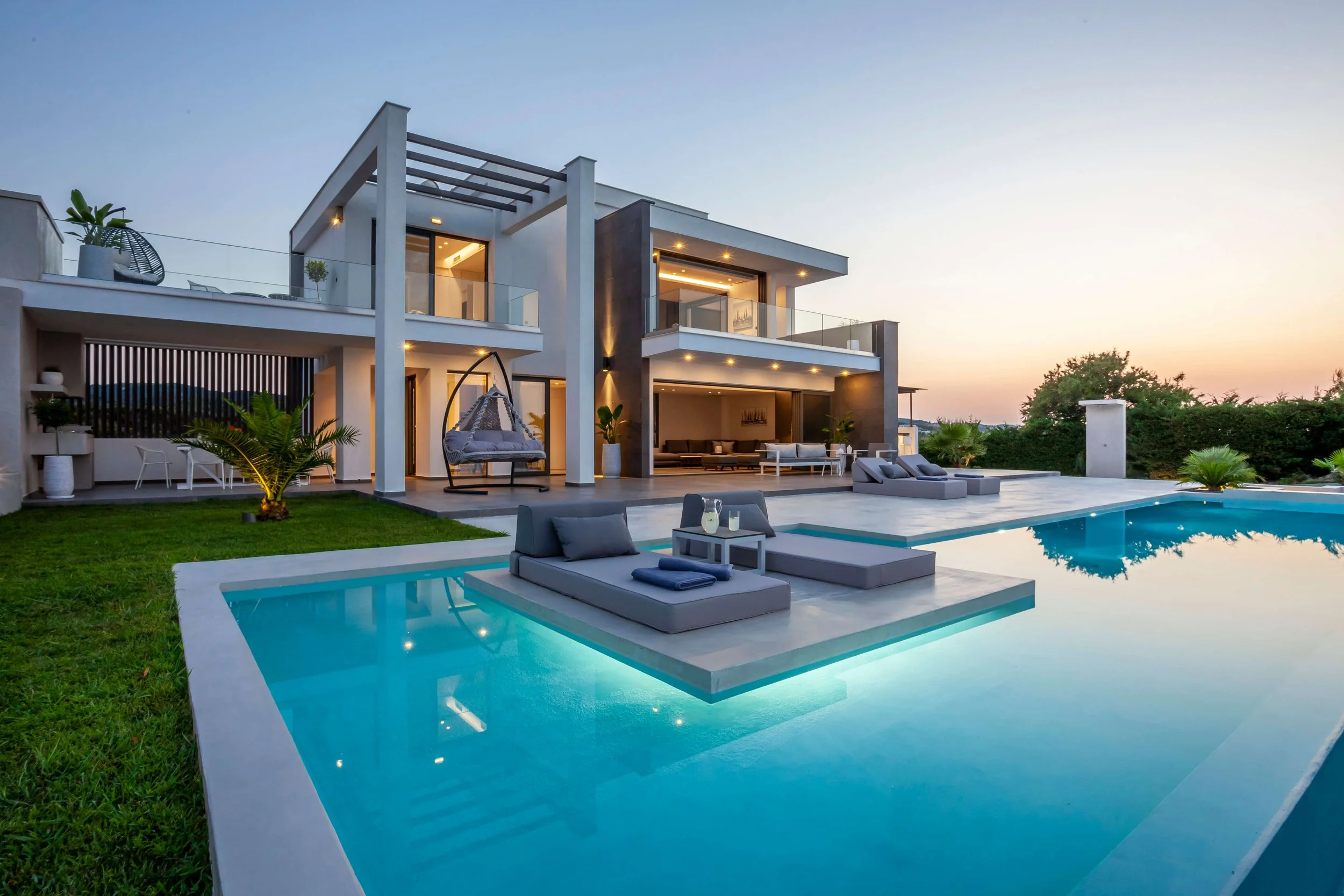 Luxurious outdoor area of Antonio Villa with infinity pool, sunbeds and panoramic Hanioti horizon