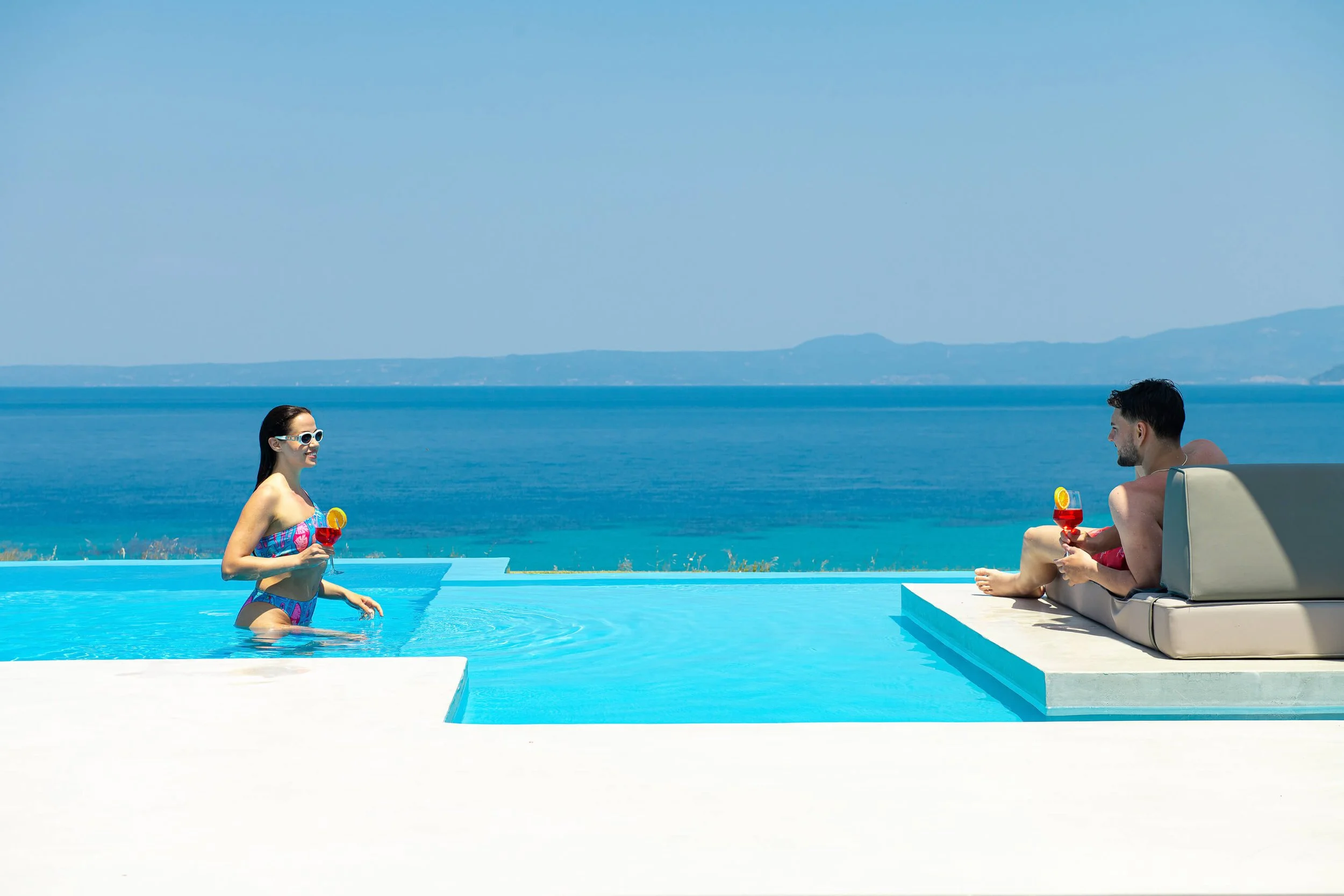Luxurious outdoor area of Antonio Villa with infinity pool, sunbeds and panoramic Hanioti horizon