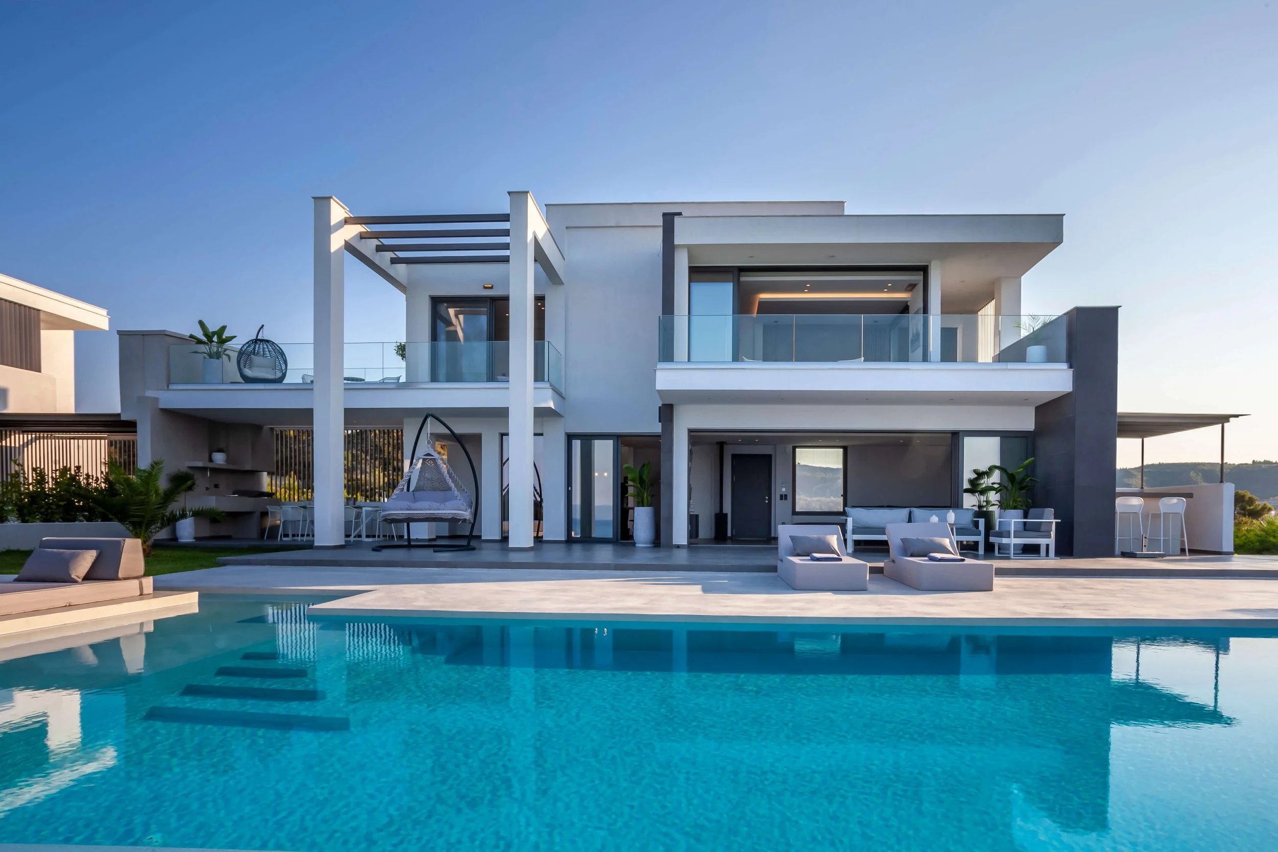 Luxurious outdoor area of Antonio Villa with infinity pool, sunbeds and panoramic Hanioti horizon