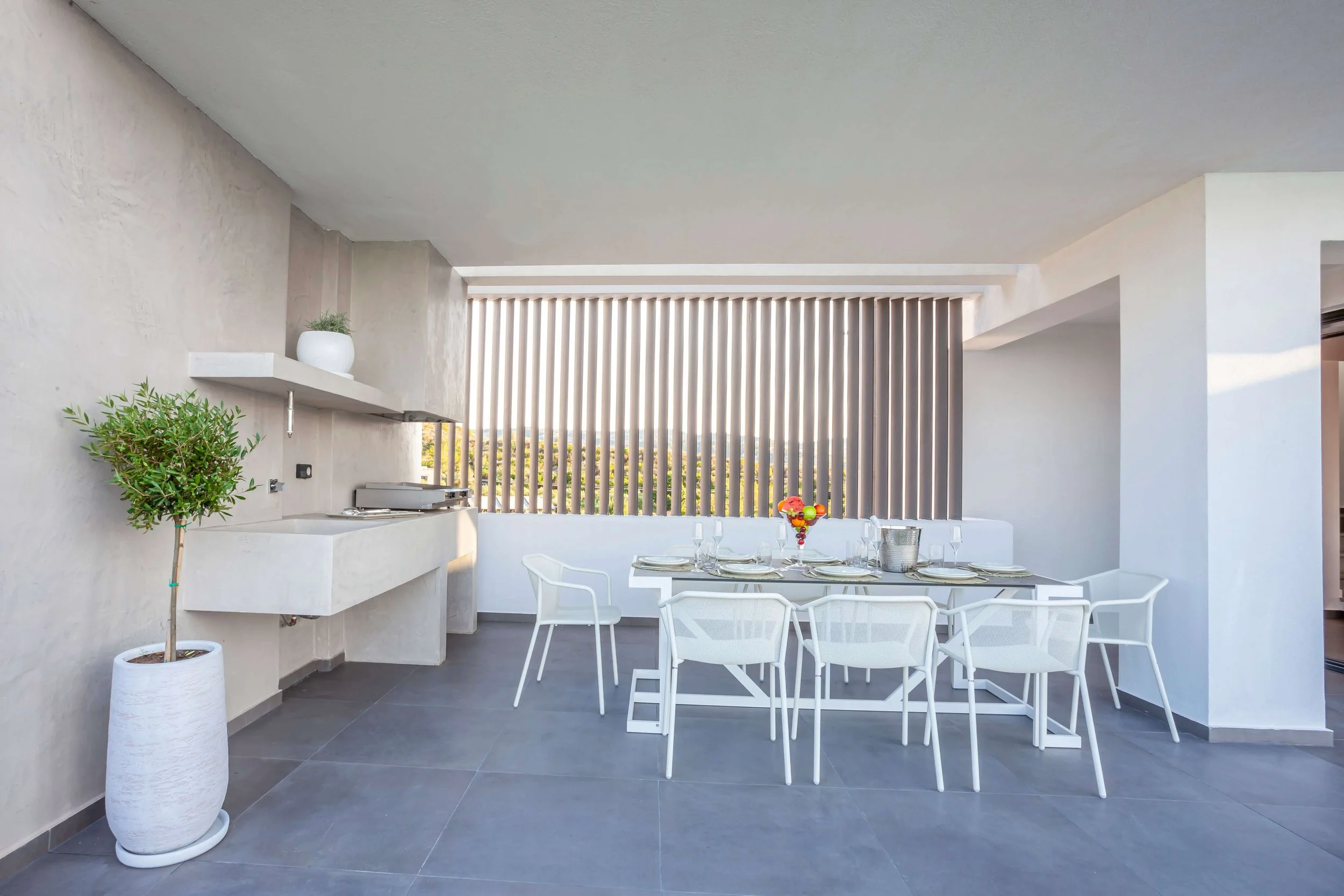 Elegant exterior bar and dining terrace of Antonio Villa with Mediterranean backdrop