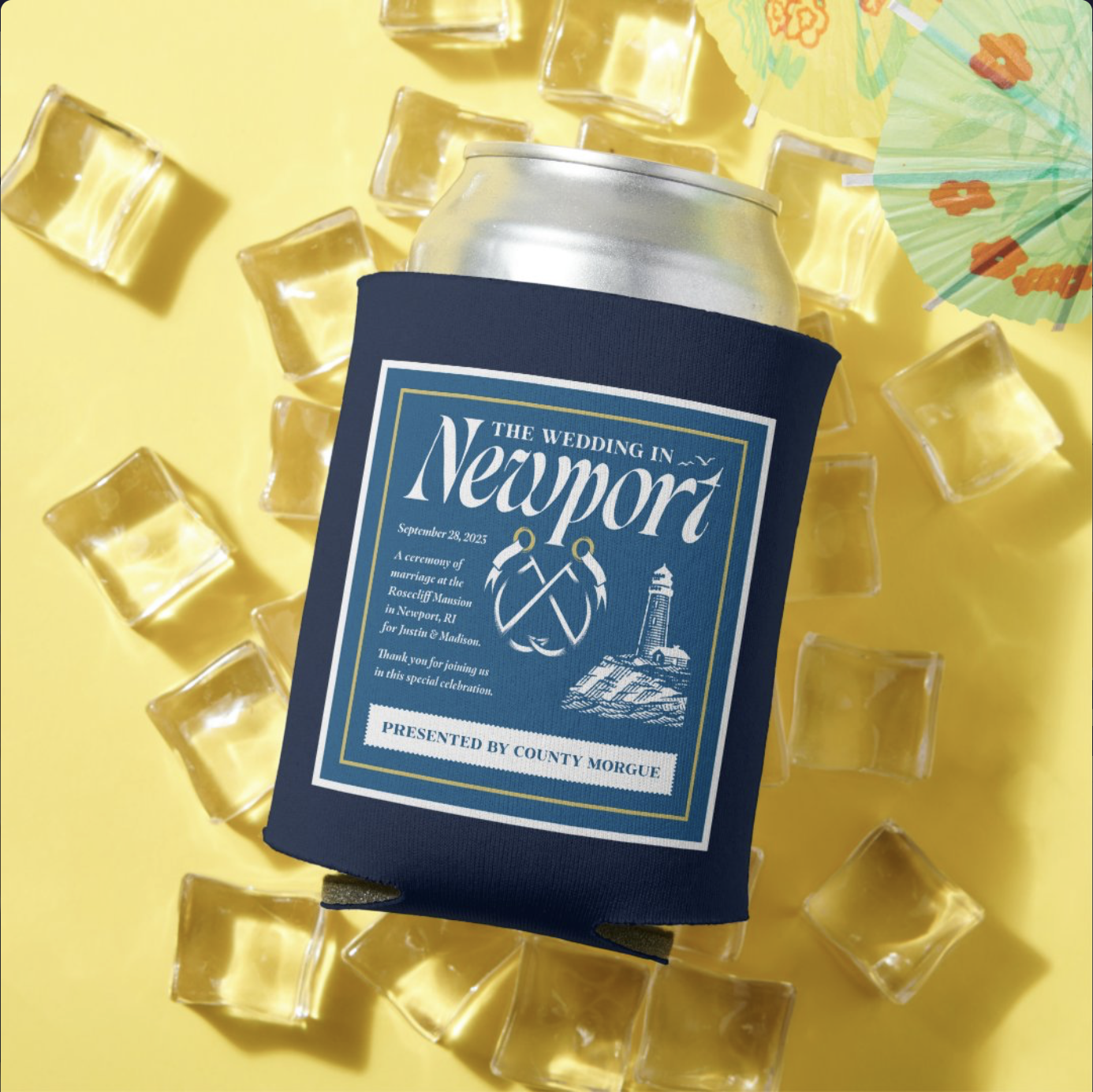 A can of beer with a navy blue koozie featuring a wedding announcement for a wedding in Newport, surrounded by ice cubes and a colorful paper umbrella on a yellow background.