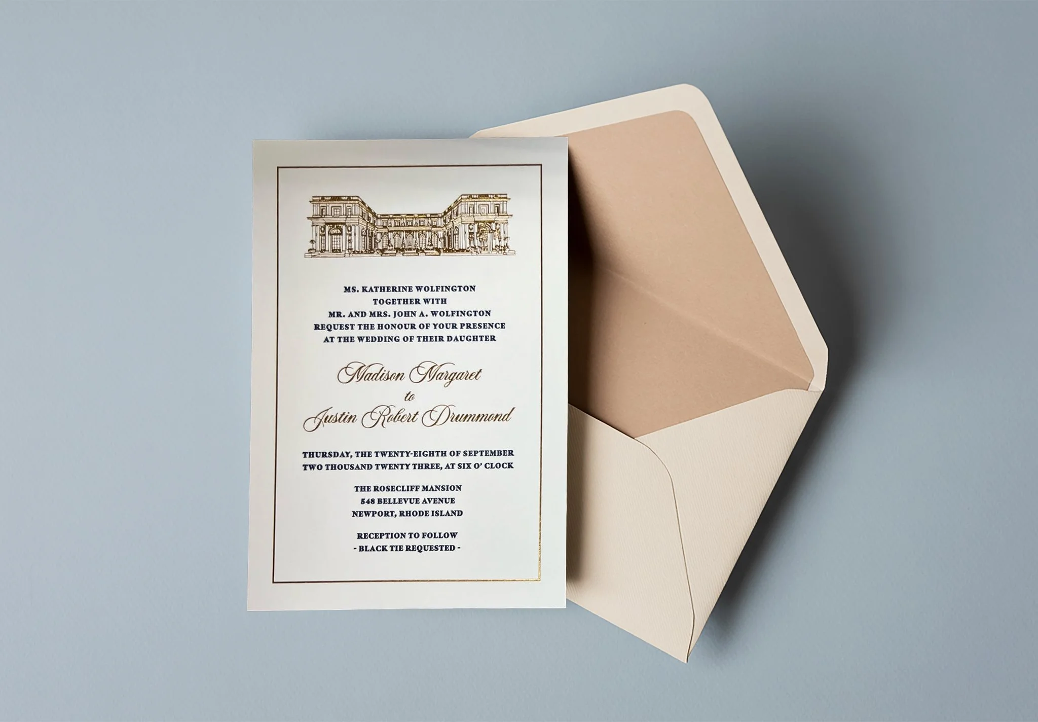 Wedding invitation card with a building illustration at the top, placed next to an open beige envelope on a light blue background.
