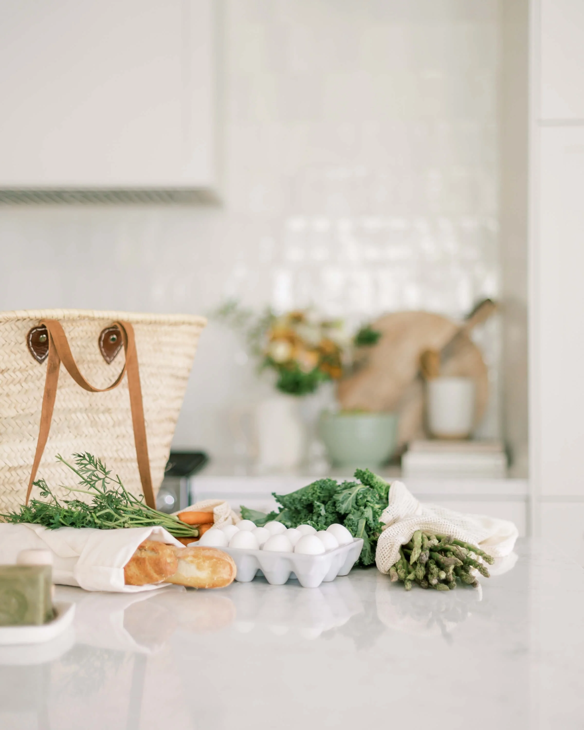 Off Beet Holistic FDN offering holistic nutrition services showing image of Fresh vegetables, eggs, and bread on a kitchen countertop with a woven basket.