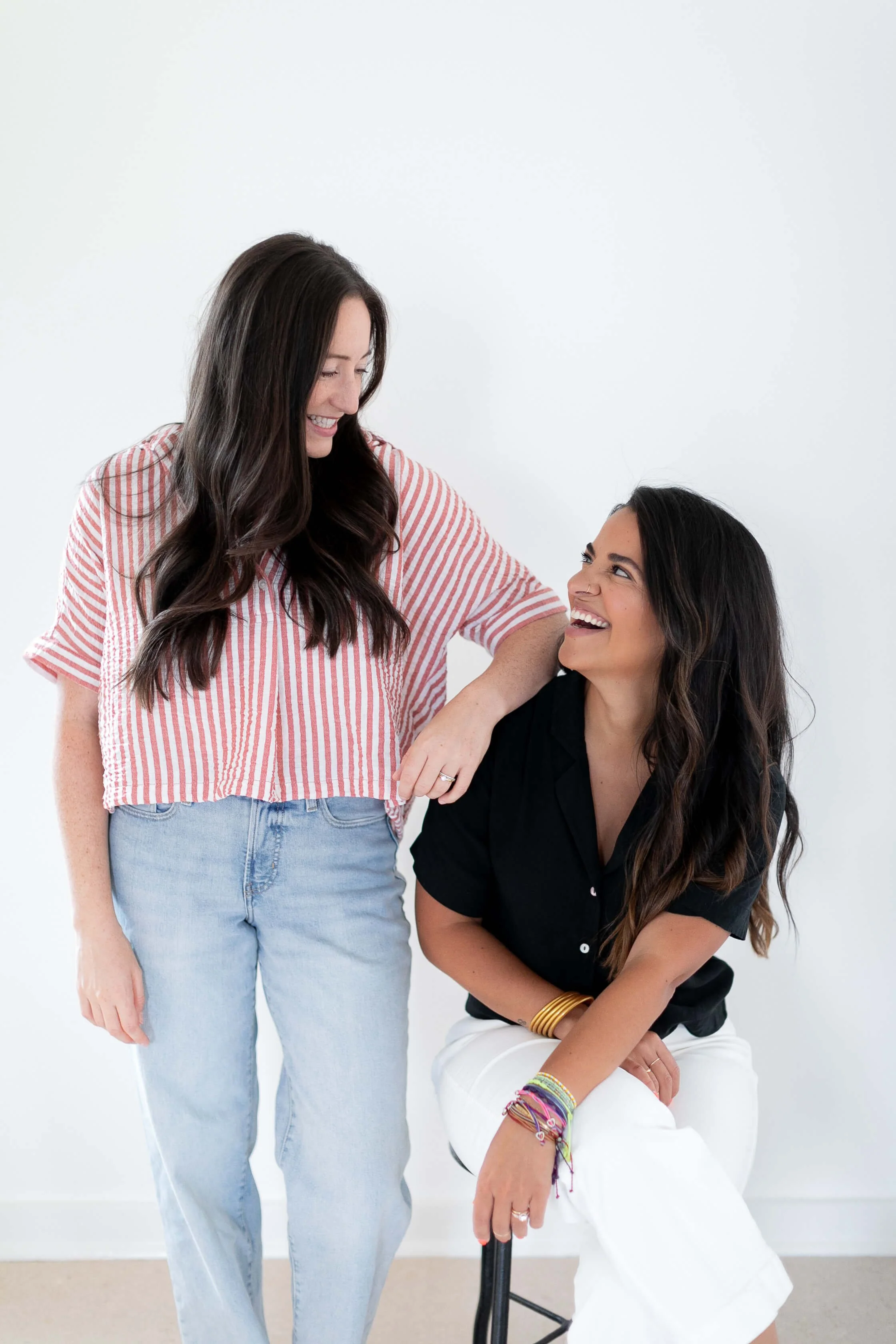 Allie Parsons and Carla Grice from OffBeetHolisticFDN, one standing and one sitting on a stool, against a plain white background.