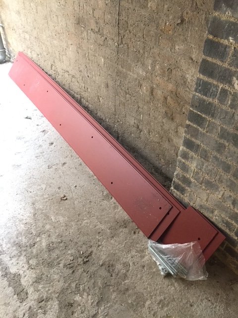 Fabricated red-primed steel flitch plates with drilled fixing holes..
